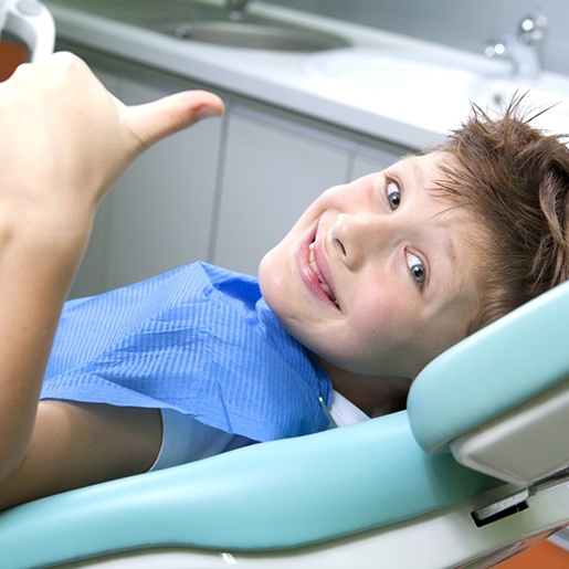 young patient smiling and giving thumbs up 