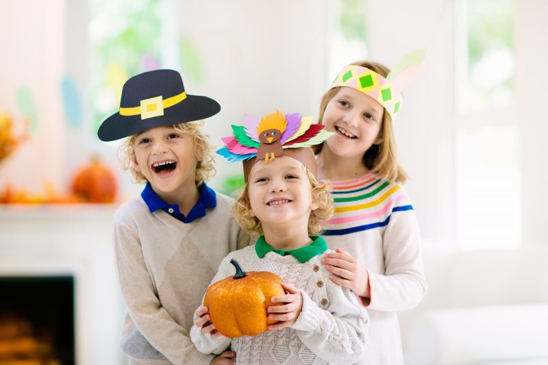 Smiling kids wearing Thanksgiving arts and crafts